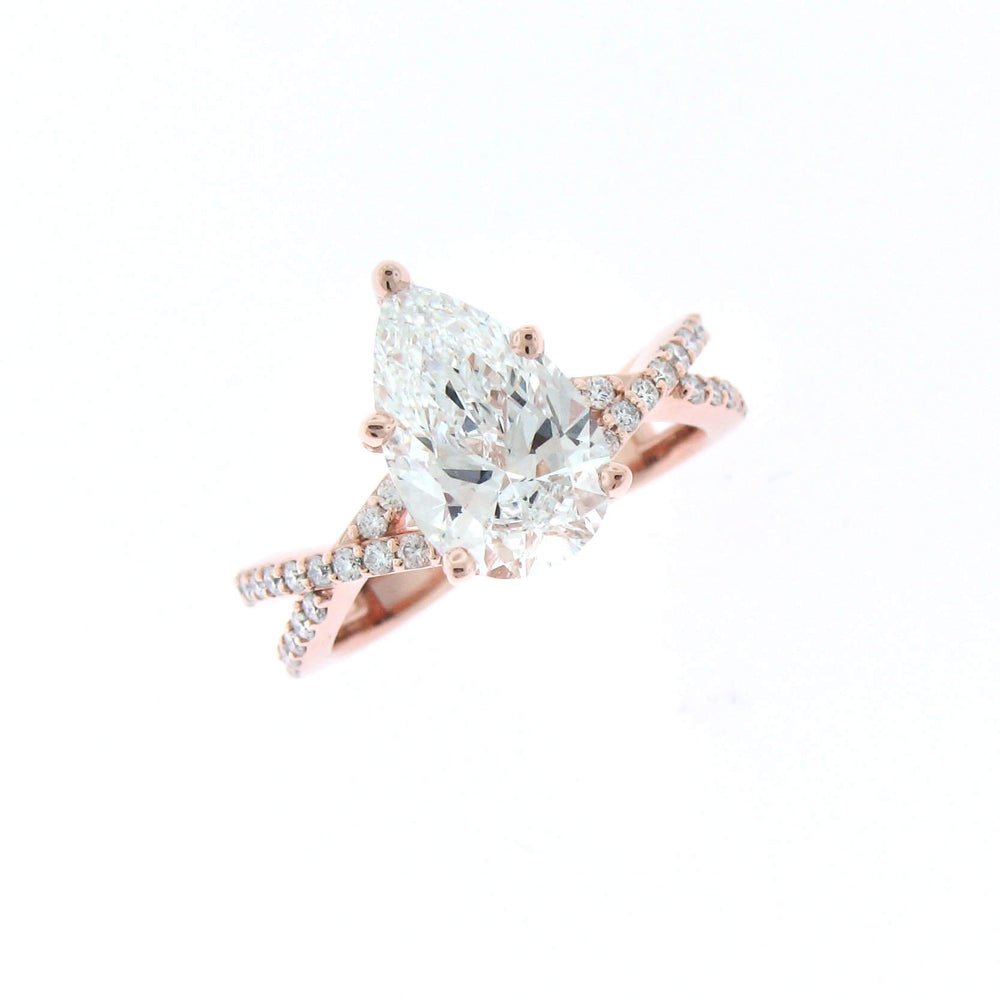 A colorless pear shape diamond set in rose gold with a diamond twist shank