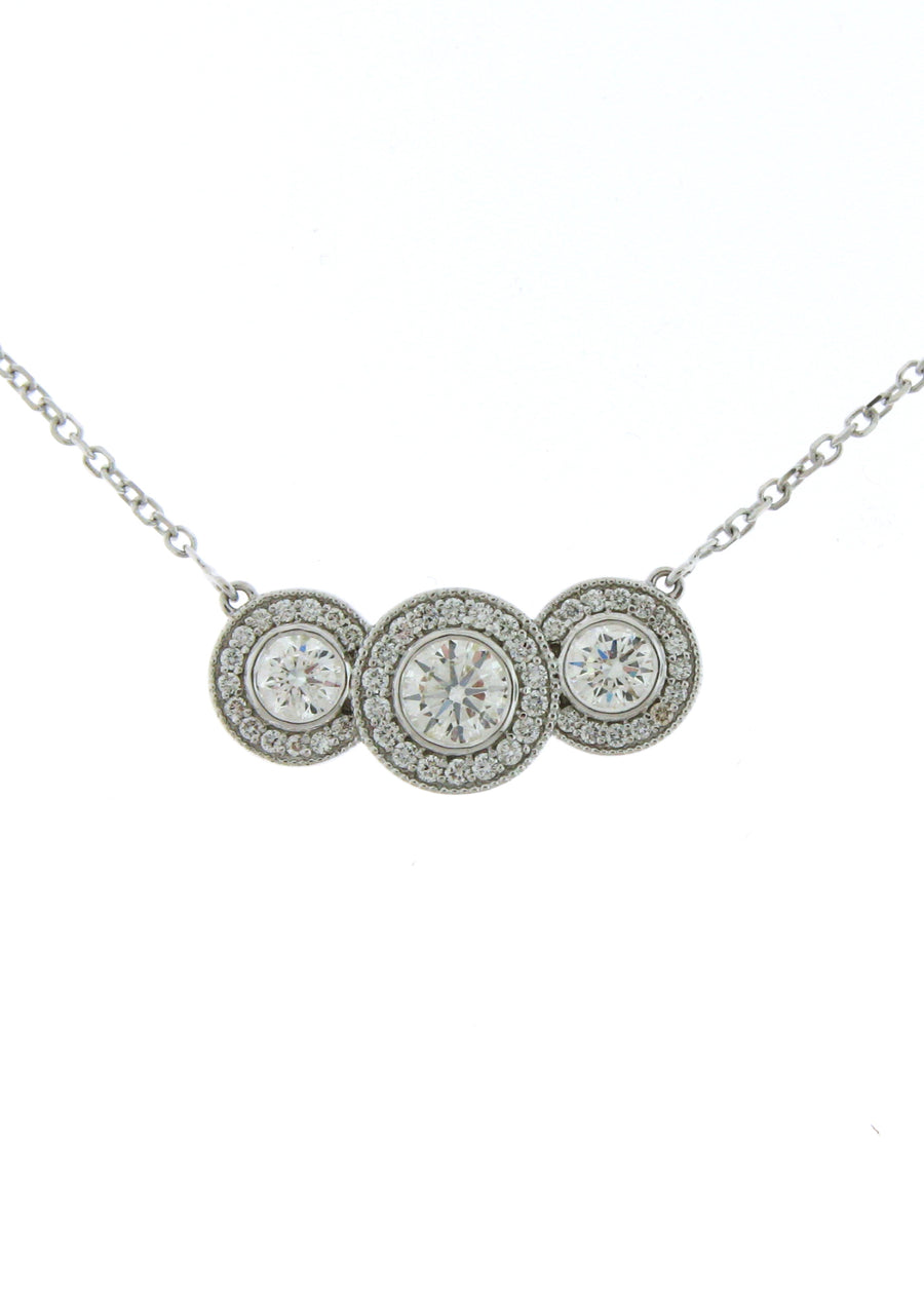 3 ideal cut round brilliant diamonds set in bezels and surrounded by pave set diamond halos