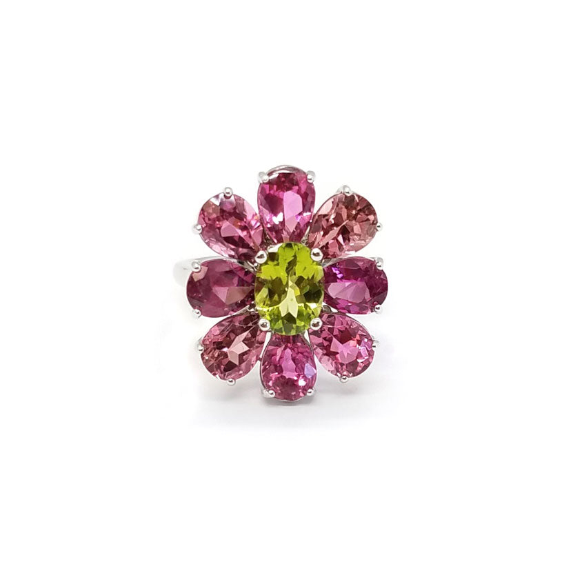 A flower ring made of multiple shades of pink tourmalines, with a peridot in the center