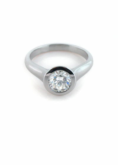 A modern bezel-set diamond solitaire in platinum