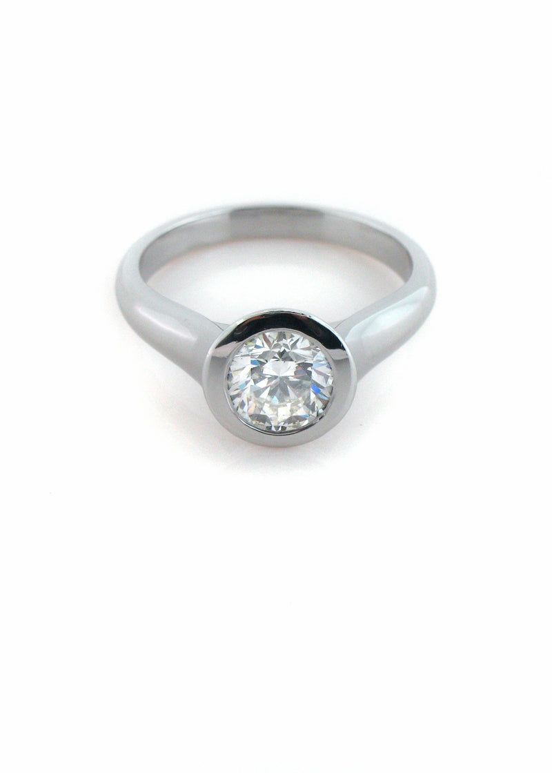 A modern bezel-set diamond solitaire in platinum, made in the studio