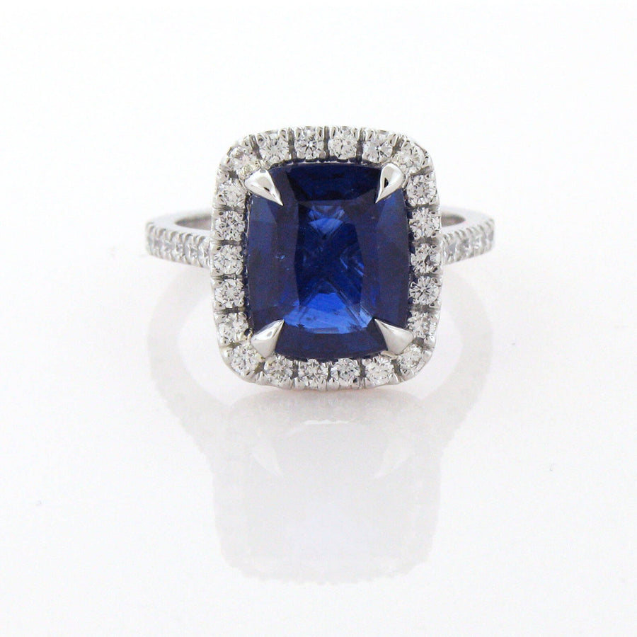 Cushion shaped Sapphire set in platinum with a diamond halo and diamond shank.