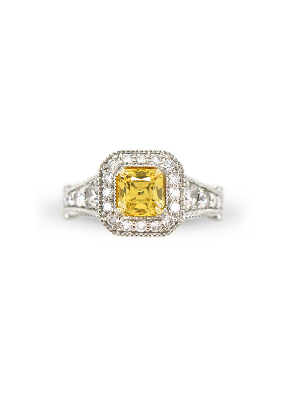A square radiant cut yellow diamond surrounded by white diamonds with a graduated diamond shank