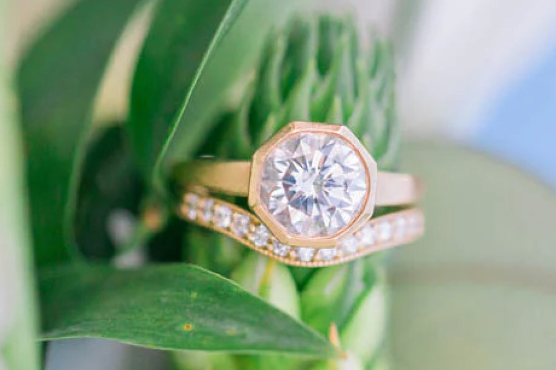 A custom yellow gold bezel-set bridal stack photographed among wedding flowers